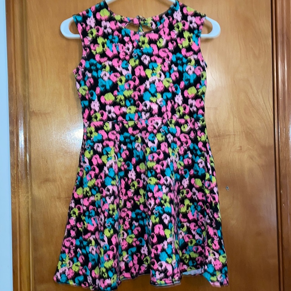 Sleeveless dress with multi colored flowers on black background.